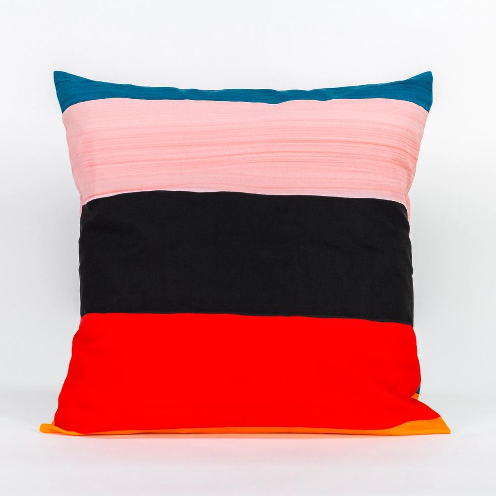 A square pillow featuring painted horizontal stripes of teal, ochre, light pink, black, and red.