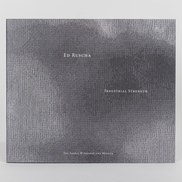 Book cover for "Ed Ruscha: Industrial Strength" featuring a textured gray and black abstract pattern with white text. Published by The Fabric Workshop and Museum.