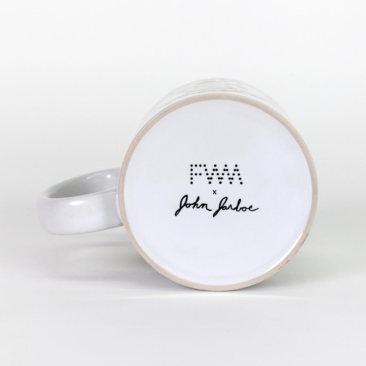 The bottom of a white ceramic mug. In black, in the center is the dotted logo for The Fabric Workshop and Museum with John Jarboe's signature below the logo. The text reads "FWM x John Jarboe"
