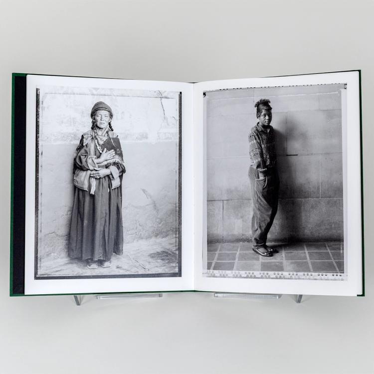 Open book displaying two black-and-white portrait photographs: one of a woman in traditional clothing standing against a textured wall, and one of a woman in casual attire leaning against a tiled wall.