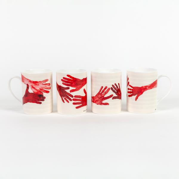 An arrangement of four tall cream-colored mugs with handles. Each mug features a different composition of red painted hands with fingers outstretched.