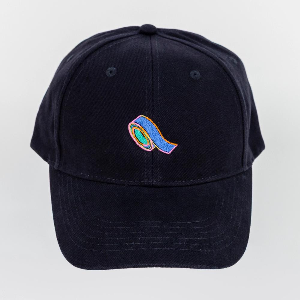 A photo of a black baseball cap with an embroidery of blue tape. The center of the tape is green and there is a pink, yellow, and orange outline to the shape of the blue tape.