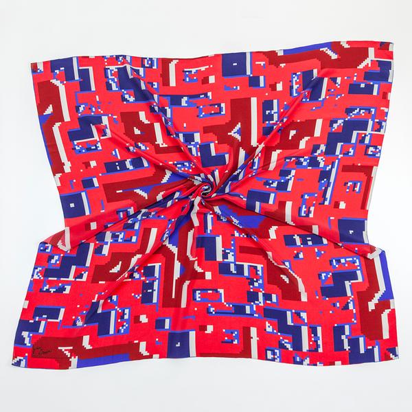 A square scarf twisted in the middle. It features a pixelated symmetrical pattern of reds and blues.