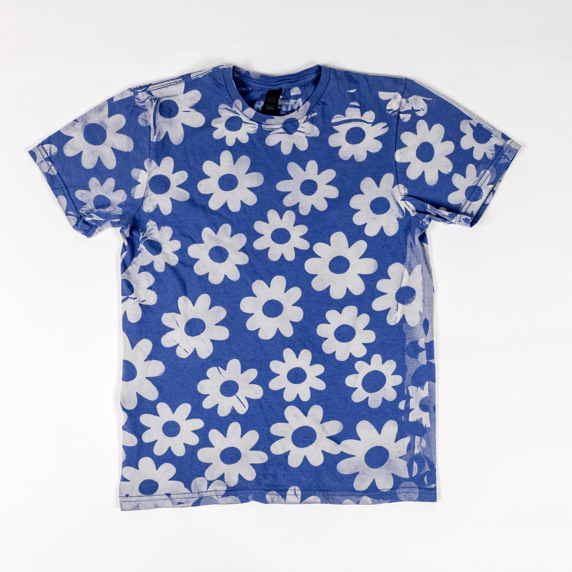 a sky blue t-shirt with a series of white daisy-like flowers printed across it.