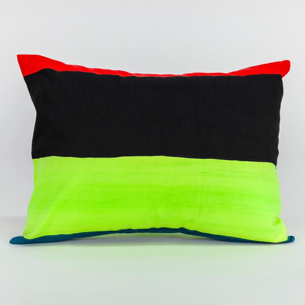 A wide rectangular pillow featuring painted horizontal stripes of, chartreuse, black, and red.