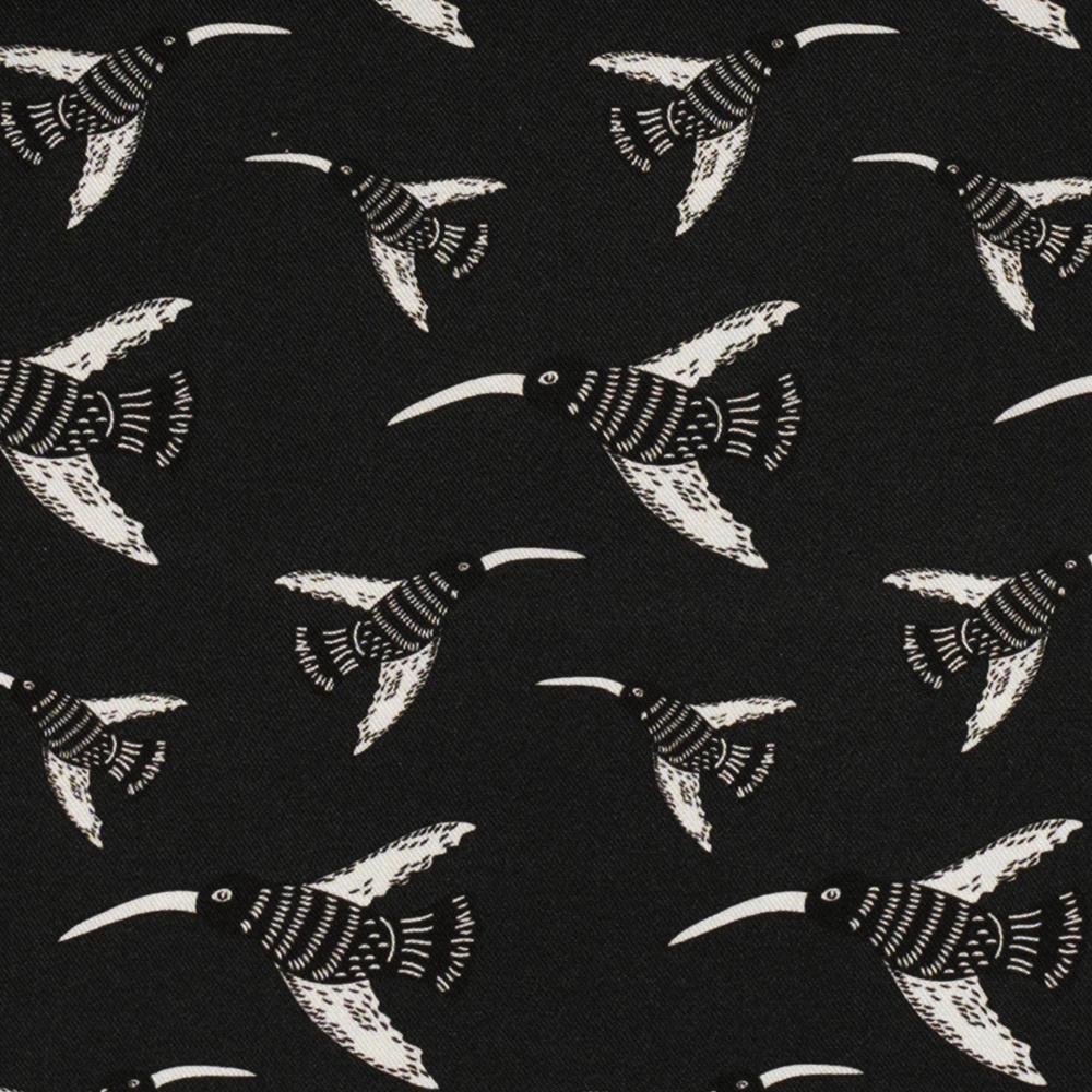 A pattern of illustrated birds with long beaks flying in different directions on a black ground.