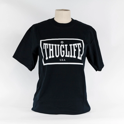 A black short-sleeve t-shirt hangs over a mannequin's bust. The white graphic on the t-shirt reads "Thuglife" with a white border around it. A registered symbol appears above the word "Thuglife" and "U.S.A." below.