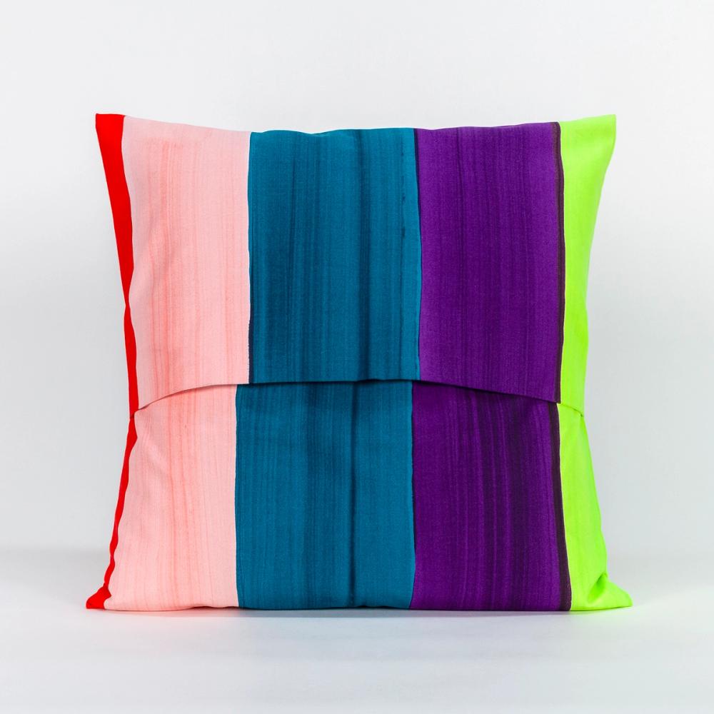 A square pillow featuring painted vertical stripes of purple, light pink, teal, chartreuse, and red. The top and bottom panels of fabric overlap in the center to create an opening.