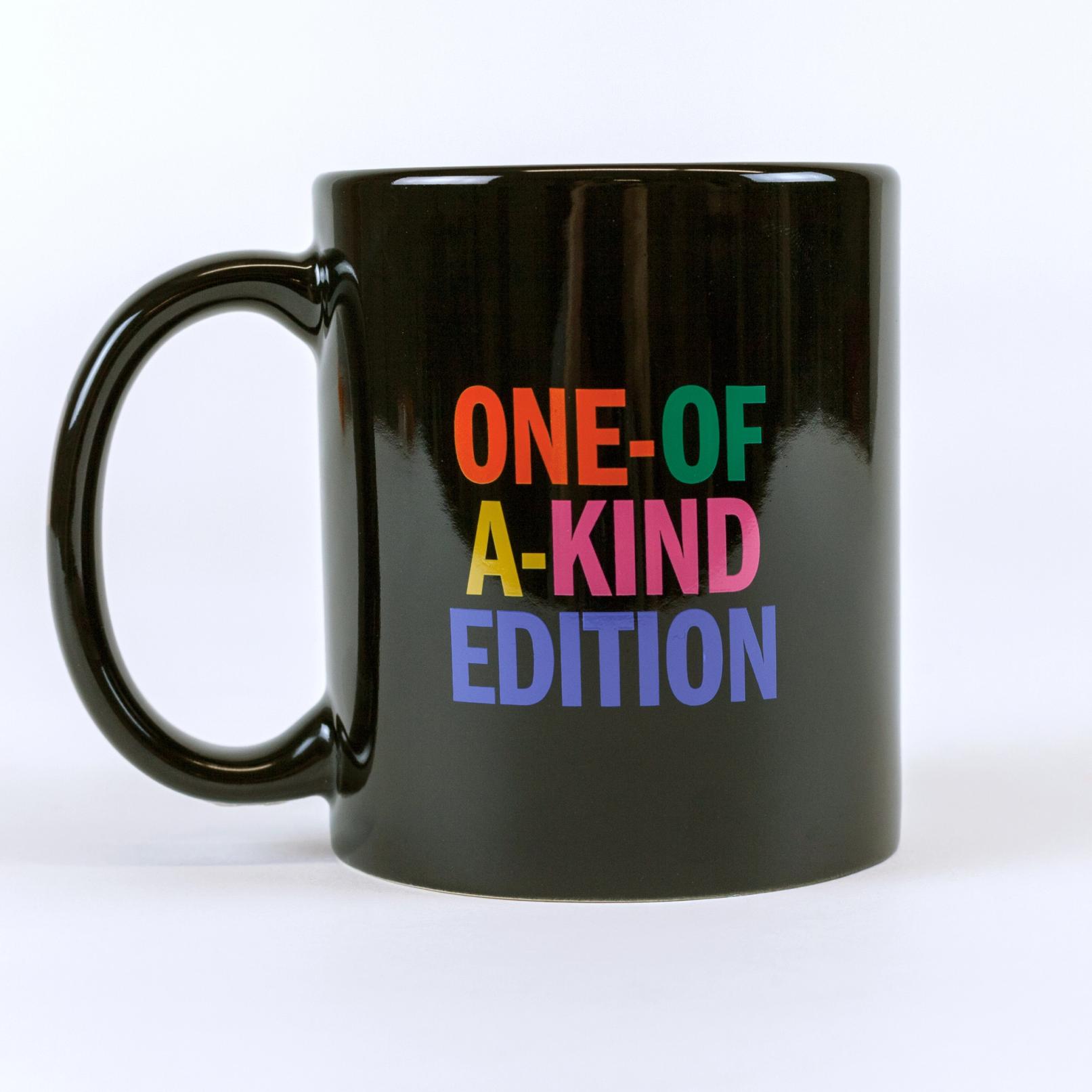 A black colored mug against a white background that reads "ONE-OF-A-KIND EDITION". Each word is in a different color: orange, green, gold, pink and blue.