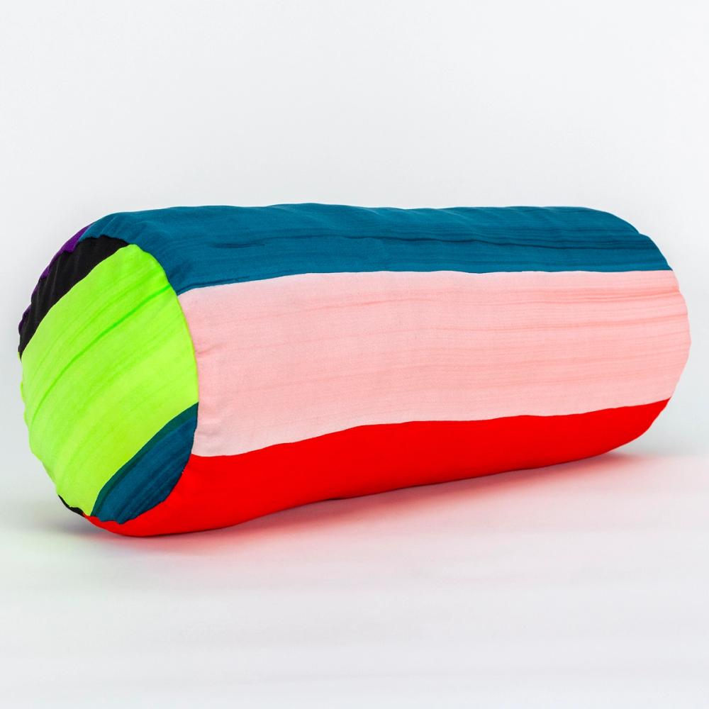 A wide round bolster pillow featuring painted horizontal stripes of, chartreuse, black, teal, light pink, purple, and red.