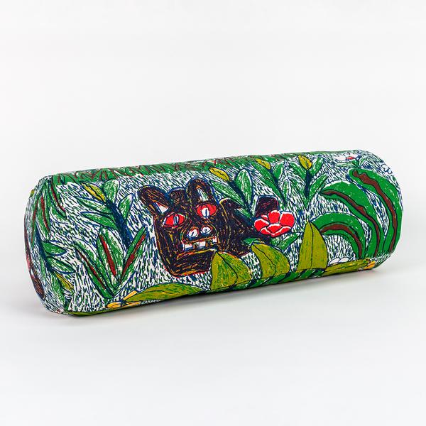 A long cylindrical pillow positioned at a 45-degree angle toward the camera. The pillow features a colorful pattern of leafy foliage, flowers, and a large jungle cat.