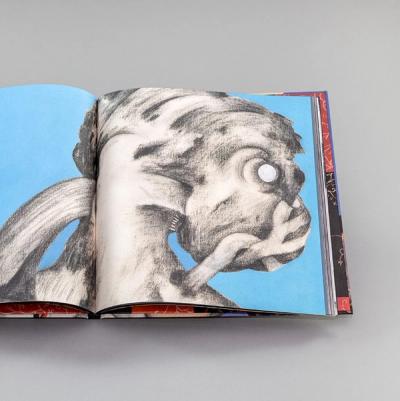 An image of a book opened to a full bleed abstract drawing taking up both pages.