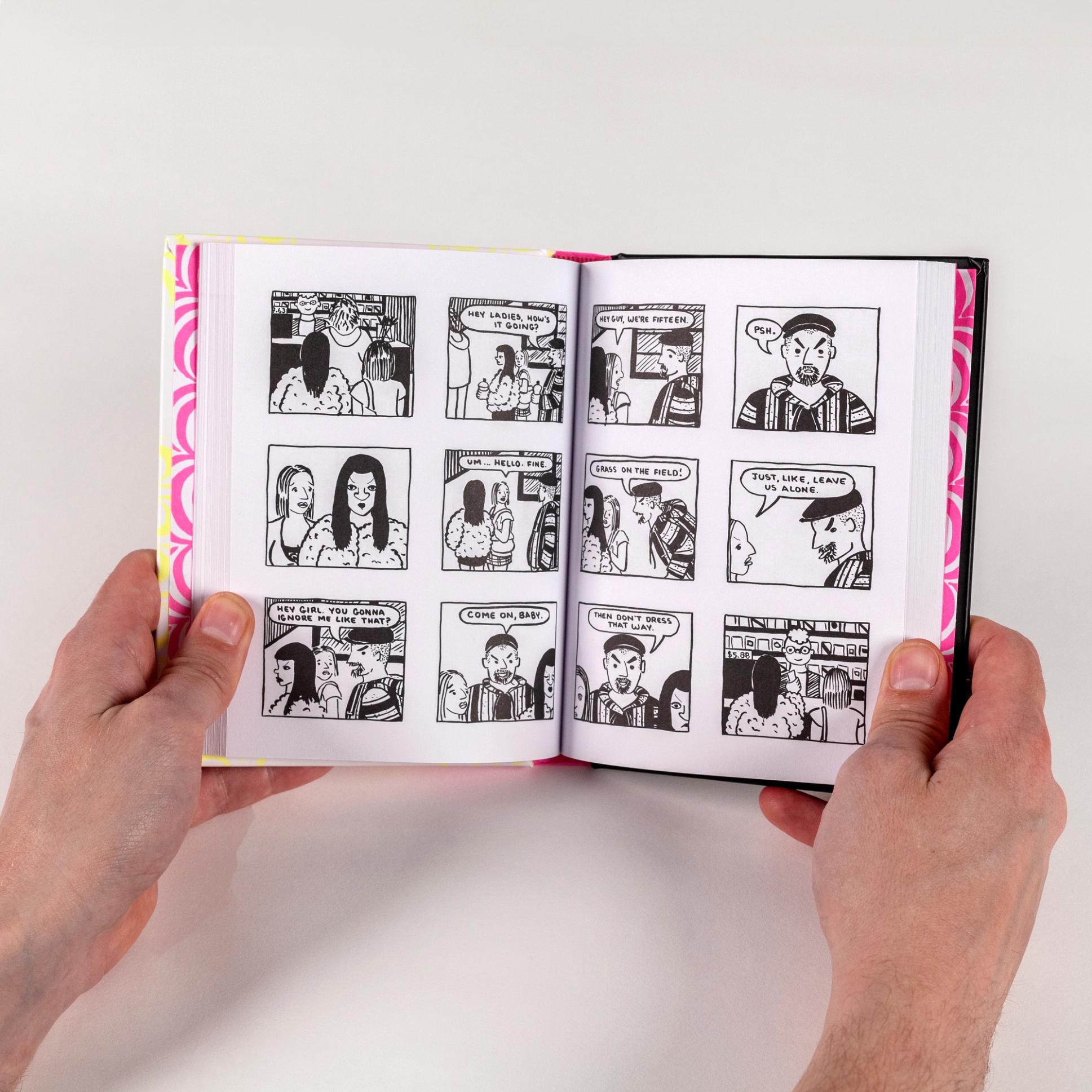 A photograph of two hands holding open a spread from a book. The book features cartoon panels of two young girls being verbally assaulted by a man.