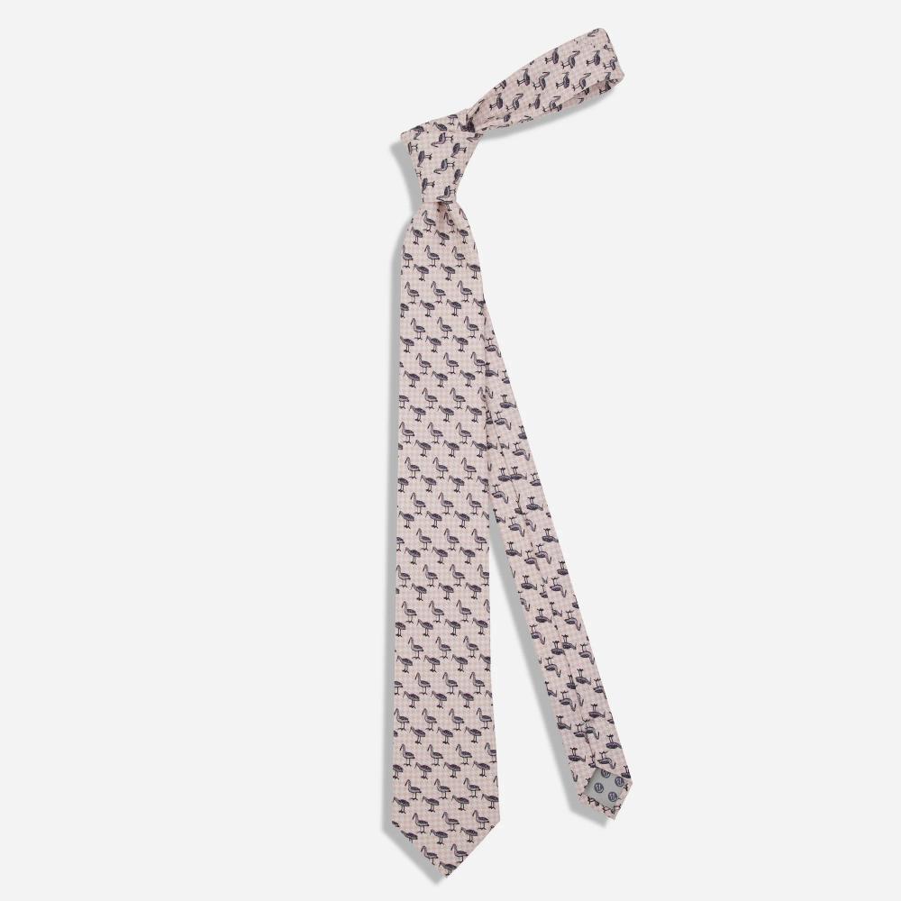 A tie with a pattern of black illustrated Bata birds with long beaks in alternating stances on a light pink and white houndstooth background.