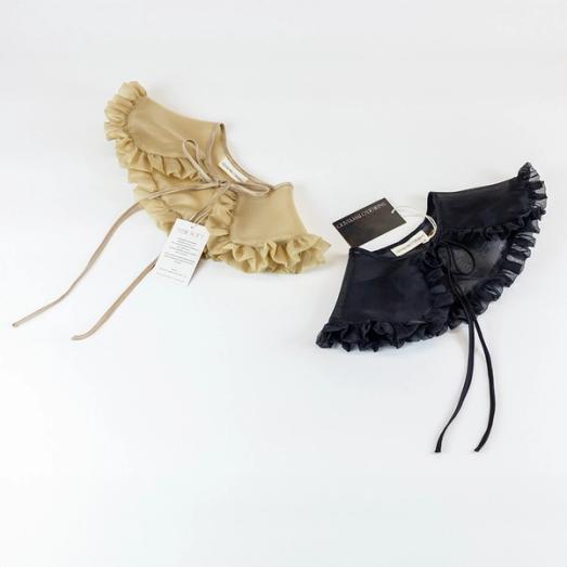 A photo of two silk organza removable collars against a white background. The collar to the left is tan, while the collar on the right is black. They are both lightly sheer, have a ruffle all the way around the outer edge, and have silk ties tied in a bow.