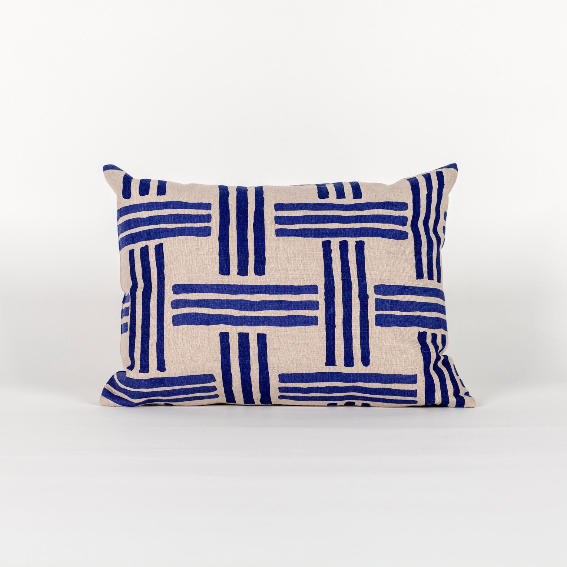 A wide rectangular pillow made of light brown fabric with a minimal weave-like pattern of blue stripes in groups of 3