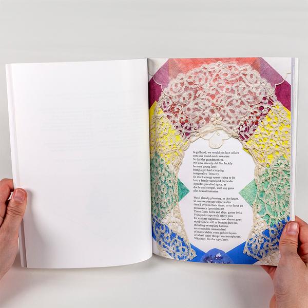 A photo of a person holding a book open. The left side of the page is blank white and on the right side there is a cream, arched doily laying on rainbow-colored collaged pieces of paper. In the center there is a typed poem.