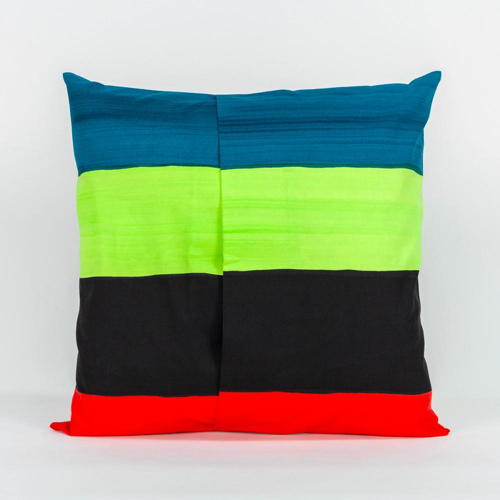 A square pillow featuring painted horizontal stripes of teal, black, chartreuse, and red. The left and right panels of fabric overlap in the center to create an opening.