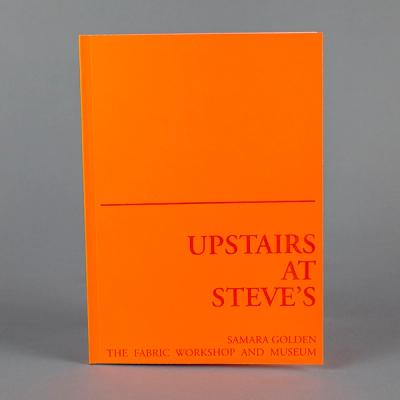 A photograph of a bright orange book standing upright. A red line divides the book cover into two; the lower half reads, "Upstairs at Steve's" and "Samara Golden, The Fabric Workshop and Museum."