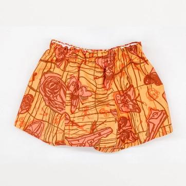 An image of backside of boxer shorts against a white background. The shorts are a light orange with pink and brighter orange patterns and brown details and outlines. The print design on the boxers shows line drawn imagery of roses, butterflies, and faces.