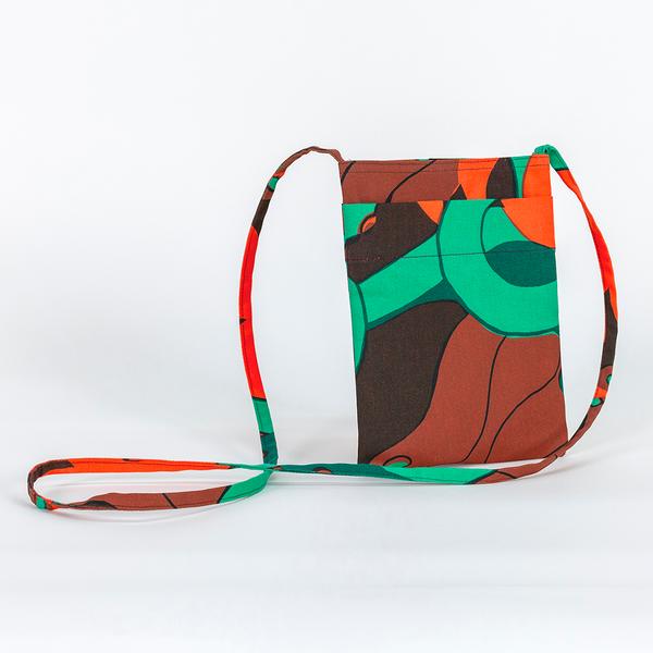 A small rectangular bag with an exterior pocket made of fabric featuring a repeating textile pattern with stylized green snakes intertwined with abstract brown shapes and bright orange spirals on a dark brown background.