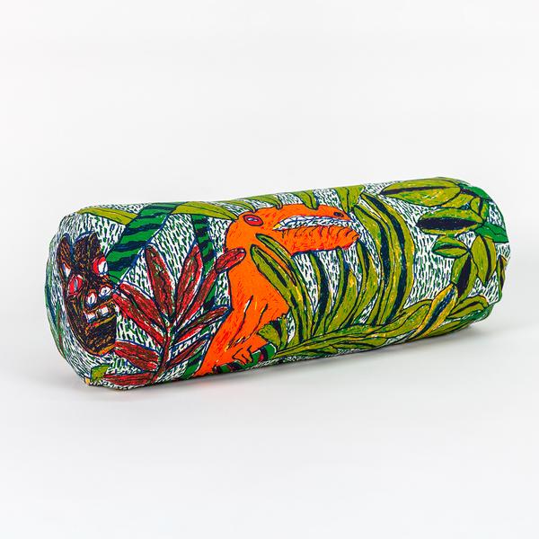 A long cylindrical pillow positioned at a 45-degree angle toward the camera. The pillow features a colorful pattern of leafy foliage and abstract jungle creatures such as a bird and a wild cat.