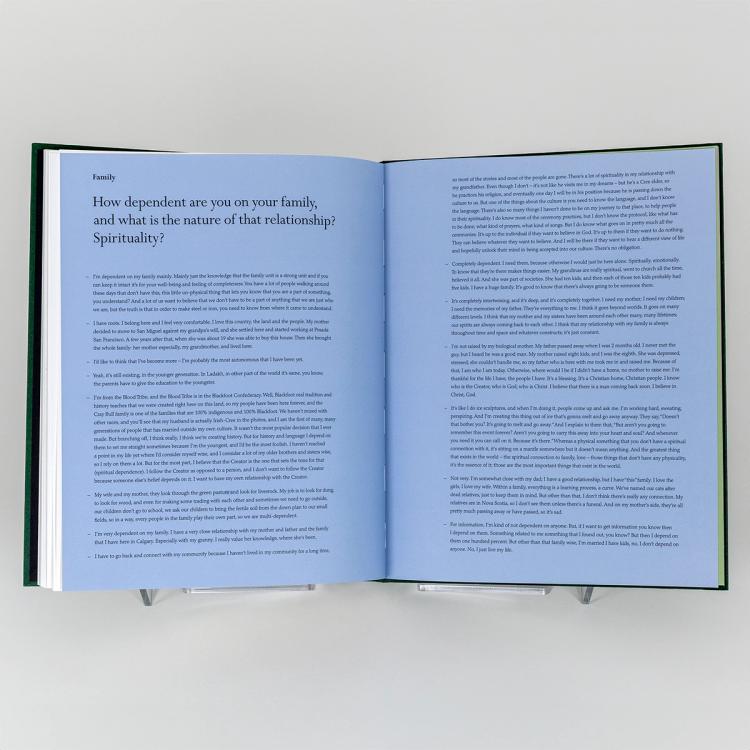 Open book displaying two pages of text on light blue paper. The text is responding to the headlining question, How dependent are you on your family, and what is the nature of that relationship? Spirituality?