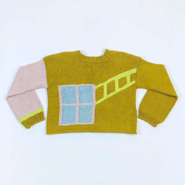 A long sleeve sweater is laying flat on a white background with the sleeves bent inwards. The body of the sweater is a medium toned yellow green. The left sleeve is pink with a green cuff and a neon yellow accent next to the cuff. On the back of the sweater, there is the light pink implication of a window with a ladder of neon yellow light emanating toward the shoulder.