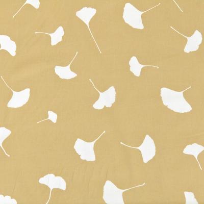 A golden-beige background with white silhouettes in the shape of ginkgo leaves (fan-like wedges with long, thin stems). The leaves are uniquely drawn with slight variations including stem length, leaf breadth, and direction.