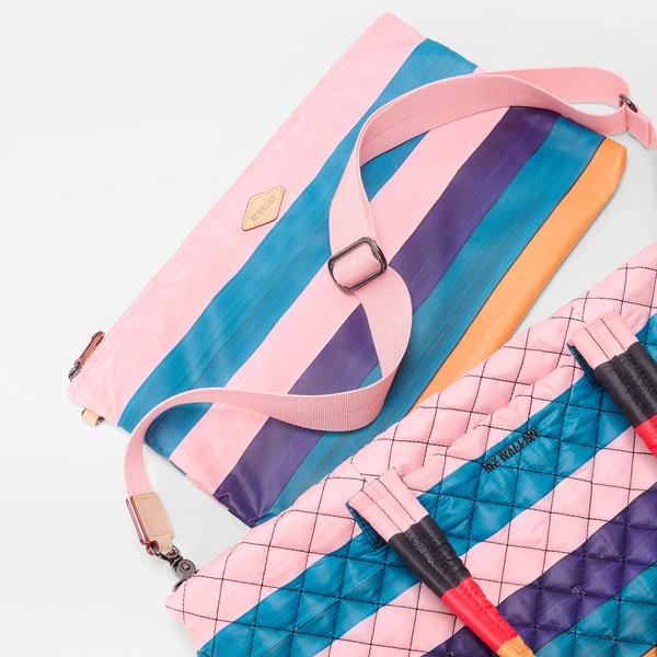A picture of a mostly pink pouch with blue and purple stripes near a larger quilted bag of the same style. 