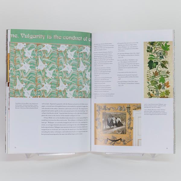 An open book showing a page with text and a photo of an ornate floral patterned wallpaper on the left, and the right shows text with two images of nature and ornate home decor that could have inspired the patterned wallpaper on the left.