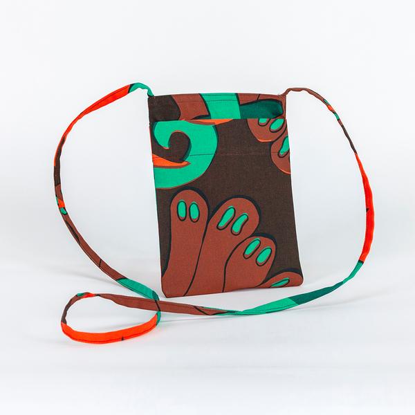 A small rectangular bag with an exterior pocket made of fabric featuring a repeating textile pattern with stylized green snakes intertwined with abstract brown shapes and bright orange spirals on a dark brown background.