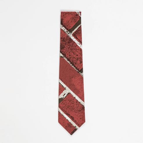 The bottom half of a folded necktie featuring a red brick pattern printed at a diagonal