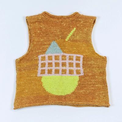 An image of the back of a sleeveless knit sweater laid flat against a white backdrop. The sweater is a variegated orange and light orange. There is a large light pink grid with a gray triangle above it and a yellow half-circle below it, resembling a setting sun. Above, a yellow bar streaks diagonally toward the triange.
