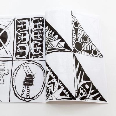 An image of a book spread laying flat on a white surface. The spread contains four illustrations on each page, split up into a grid made of equal sizes. The illustrations are gestural and created with black ink on white paper. The drawings are of geometric and organic patterns and illustrations.