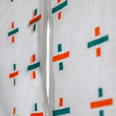 Close up image of a white yukata with cross designs adorning the garment in orange and green.