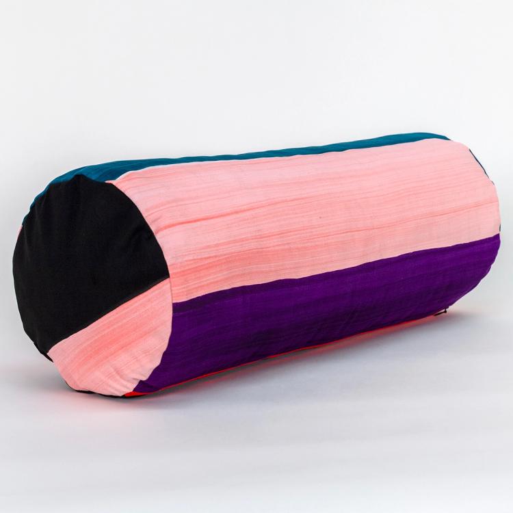A wide round bolster pillow featuring painted horizontal stripes of black, teal, light pink, and purple.
