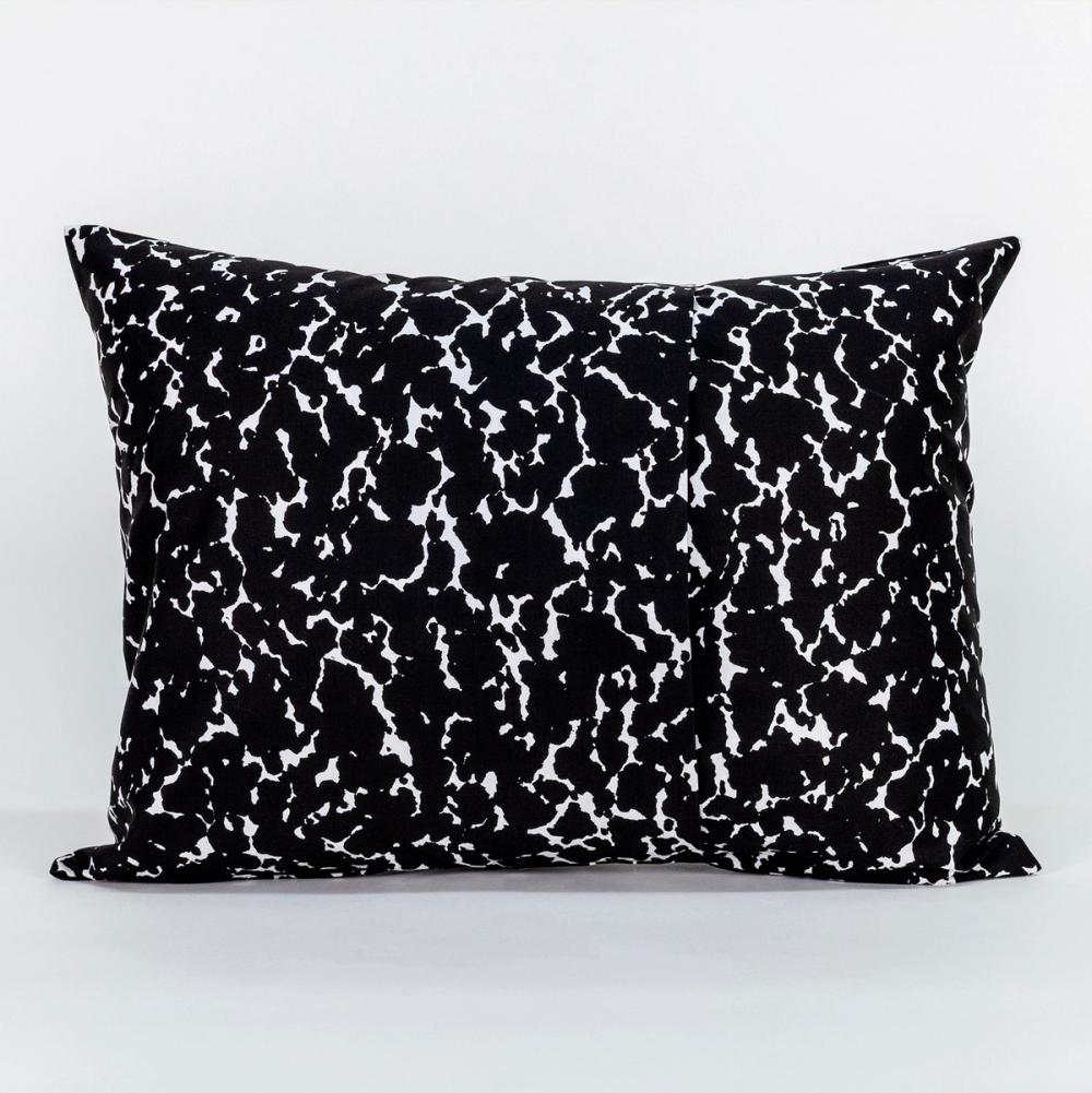 A wide rectangle-shaped pillow featuring a speckled black and white design like the kind found on a student's composition notebook. The left and right panels of fabric overlap in the center to create an opening.