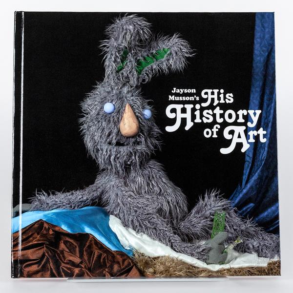 A cover of a book featuring a gray scraggly rabbit as a puppet lounging in reference to Ingres' painting "La Grande Odalisque" and holding a clear and green bong.