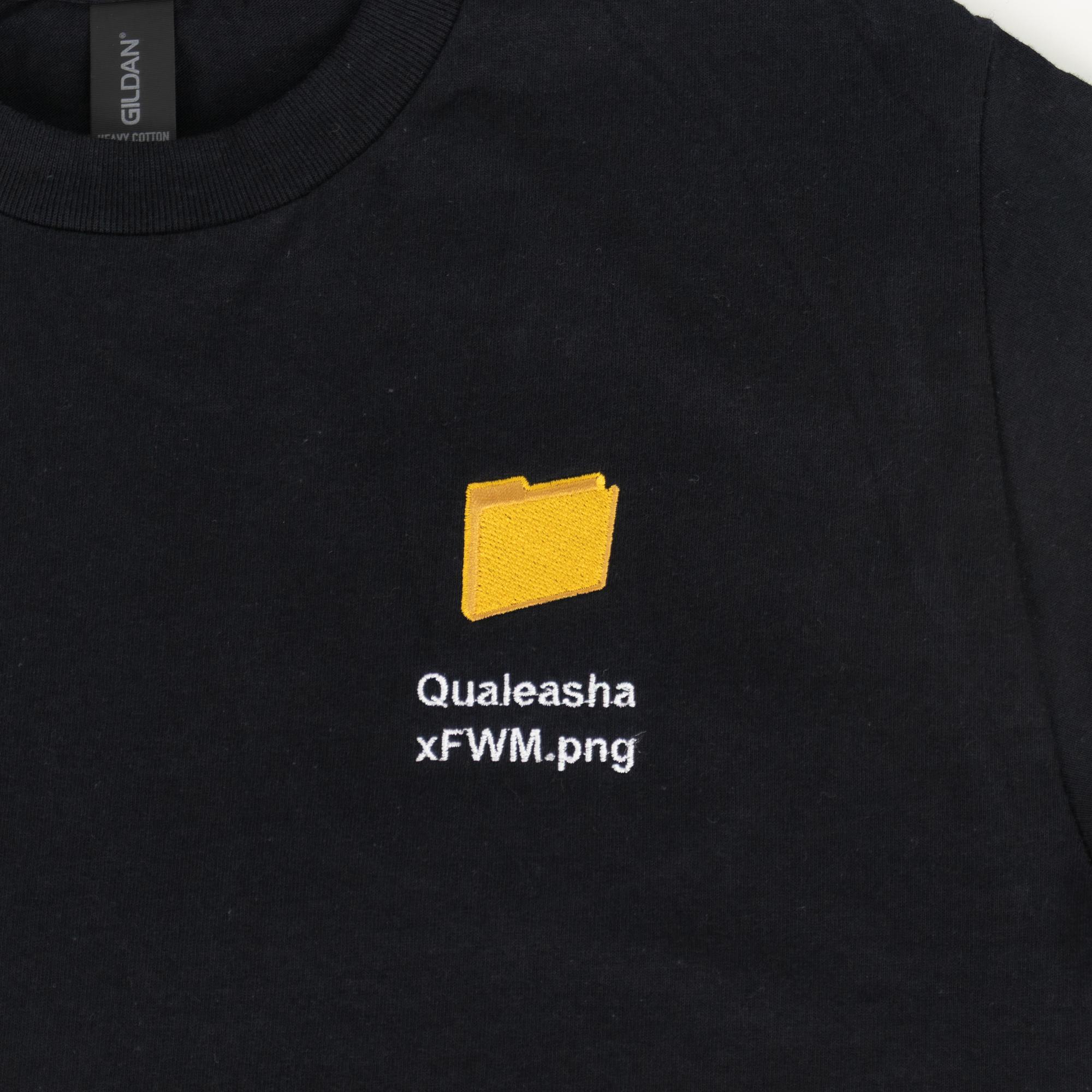 A detail photo of a black t-shirt with a 1.5 inch yellow computer desktop folder embroidered on the upper left side of the shirt. Below the folder reads "Qualeasha x FWM.png" in white embroidery thread.
