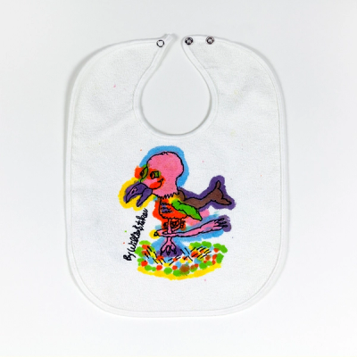 A white baby bib with a drawn and hand-painted image of a baby bird with a pink head outlined in blue. Its multi-colored body stands with one foot on a colorful patch of grass with its other foot bent sideways.