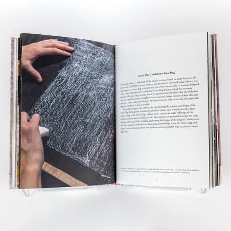 A photograph of a book spread with a photo on the left and text on the right. The book image features two creating a white chalk rubbing of a woven texture against a black ground. 