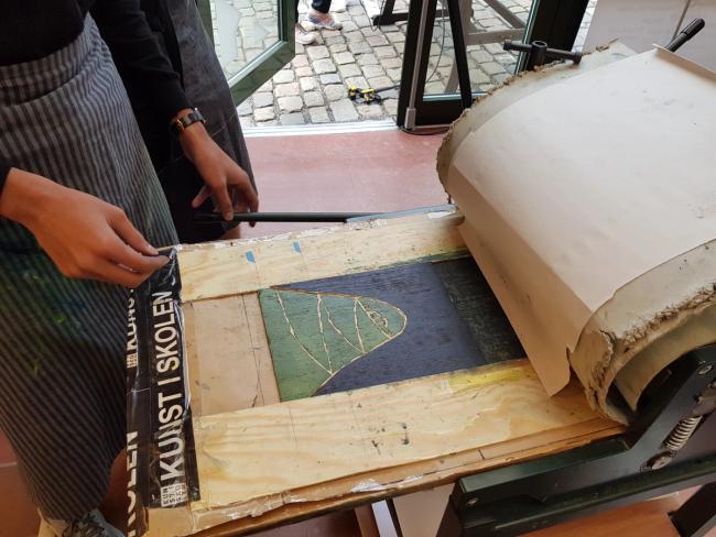 Treplaten må legges nøyaktig på plass i grafikkpressa.