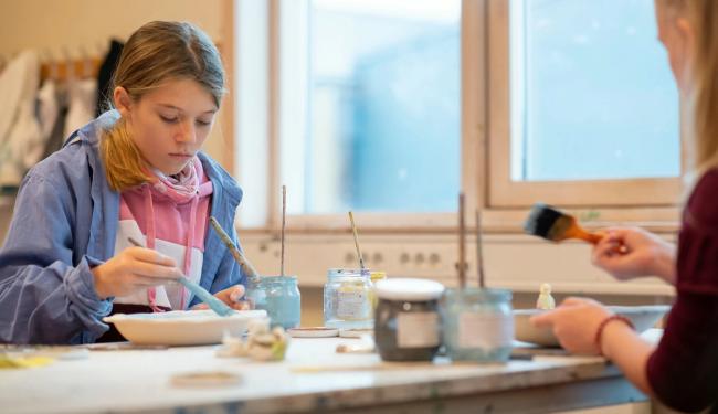 Elever gjør håndarbeid i klasserommet.