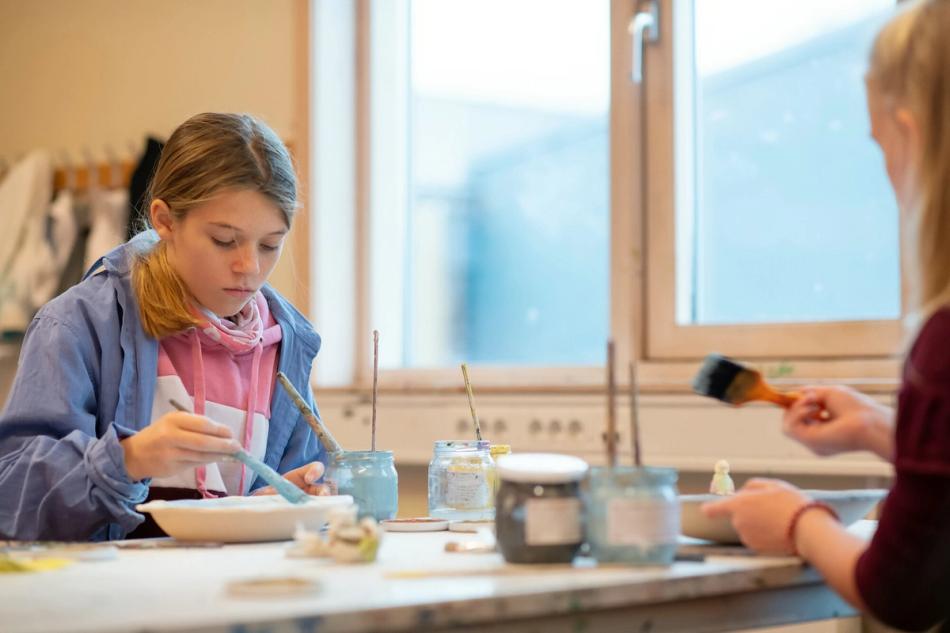 Elever gjør håndarbeid i klasserommet.