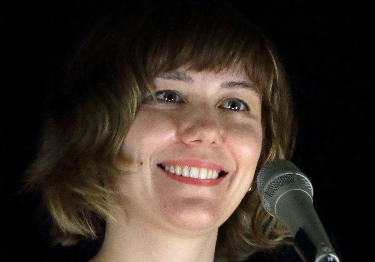 Molly Tuttle smiling at a microphone during a performance