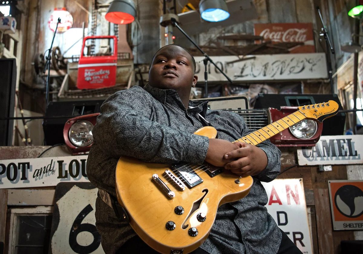 Christone Kingfish Ingram posing with an electric guitar
