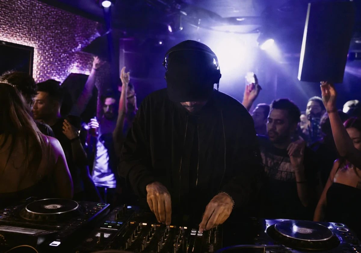 Anonymous UK garage DJ performing in a violet-lit London club