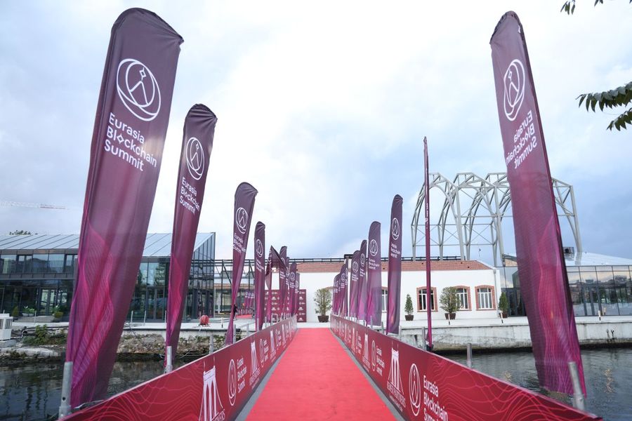 Red-carpet arrival walkway lined with Eurasia Blockchain Summit feather flags and branded barrier panels - BACKSTAGE Event production