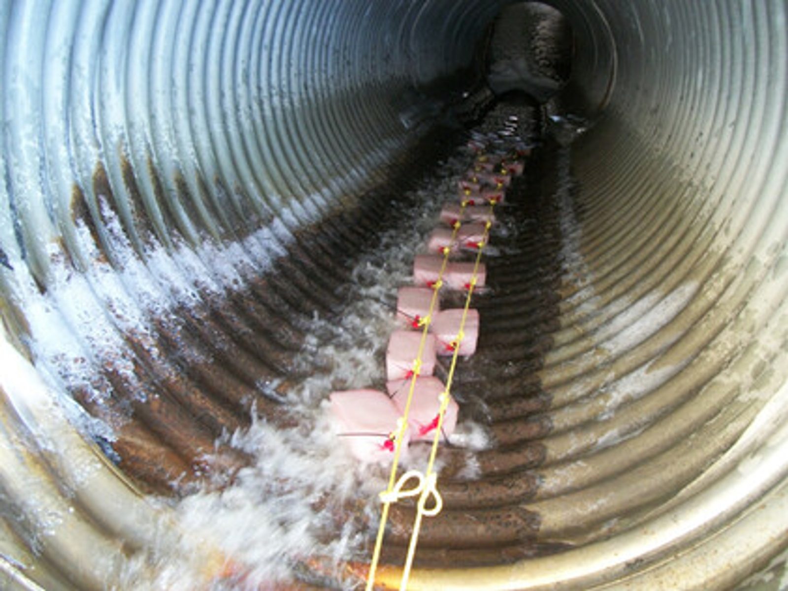 Gel Flocculant blocks chained through a corrugated metal culvert